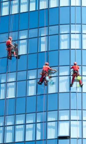 86751573 - five workers washing windows in the office building